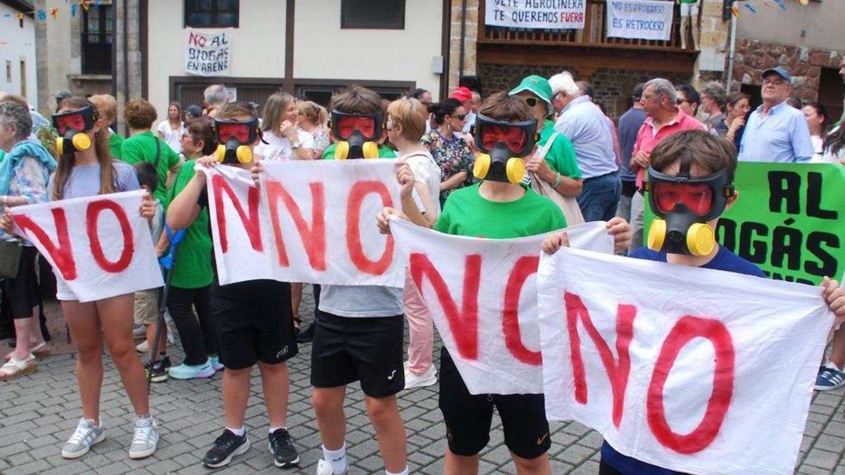 Varios niños con máscaras antigás de juguete durante una protesta contra la planta de biogás en Arenas.