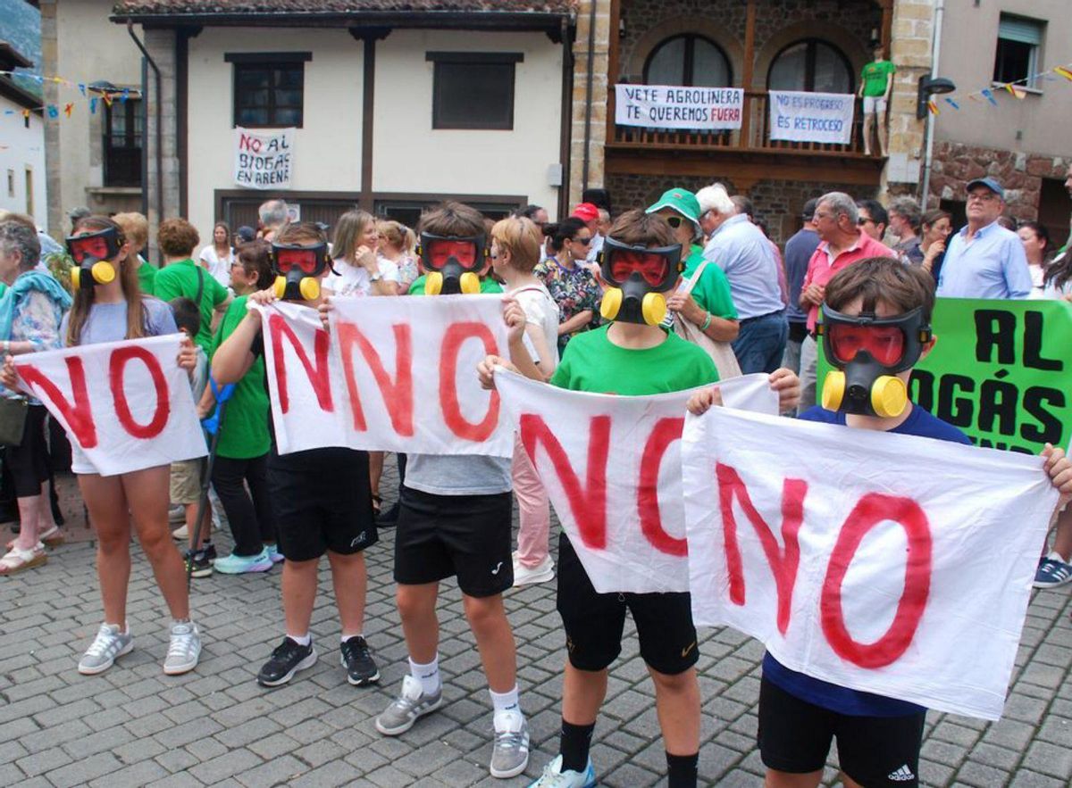 Varios niños con máscaras antigás de juguete, ayer, en la protesta contra la planta de biogás en Arenas. | RAMÓN DÍAZ