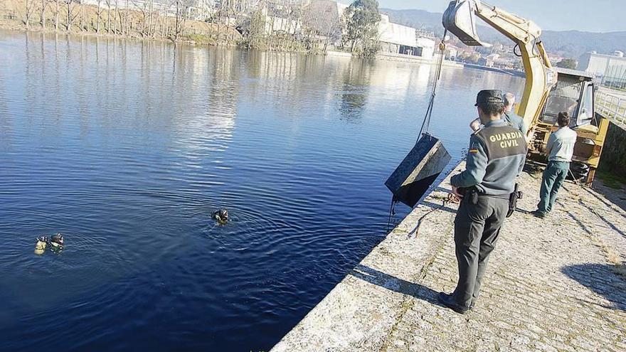 La Guardia Civil recupera una de las máquinas de tabaco arrojadas al río Ulla. // G. Civil