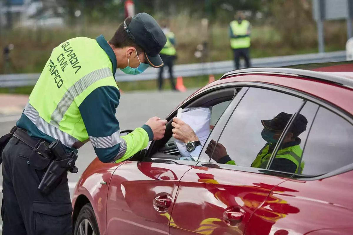 Un Guardia Civil pide la documentación a un conductor.