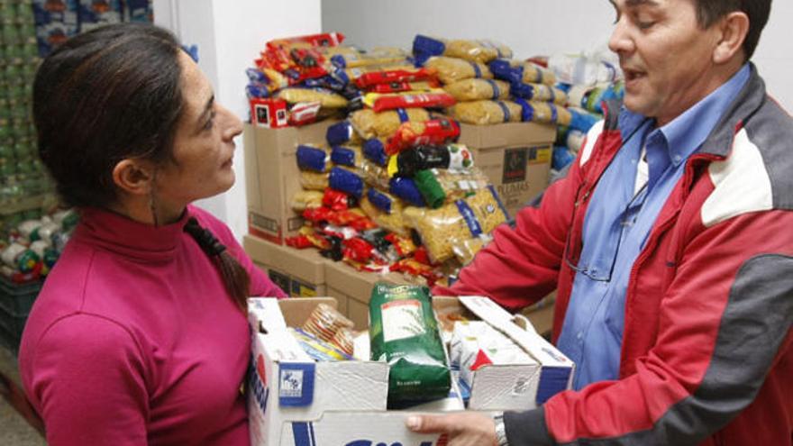 María recibe un paquete con arroz, pasta, tomate, leche y aceite una vez a la semana, como otras 350 familias que acuden a la asociación Padre Huelin.