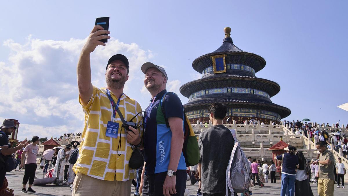 Unos turistas se hacen un 'selfie' frente al Templo del Cielo de Pekín, el pasado 15 de junio