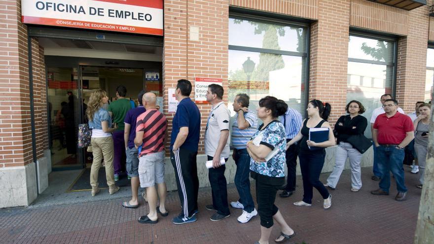 Personas hacen cola en las puerta de una oficina de empleo.