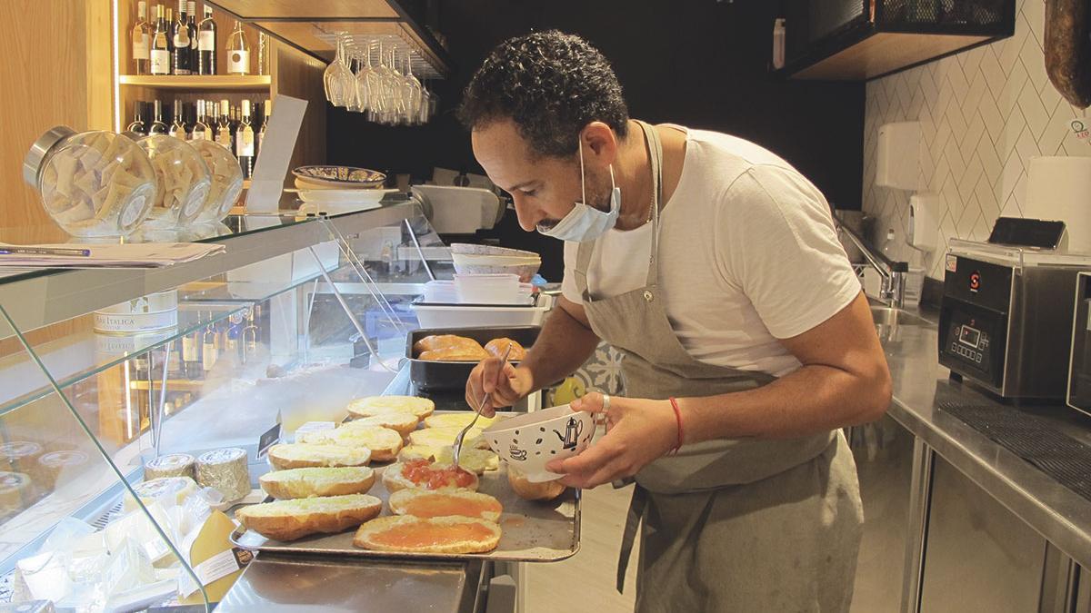 El chef Claudio Lemos  preparando unos ‘bocadillos de autor’ en el Colmado Colom.