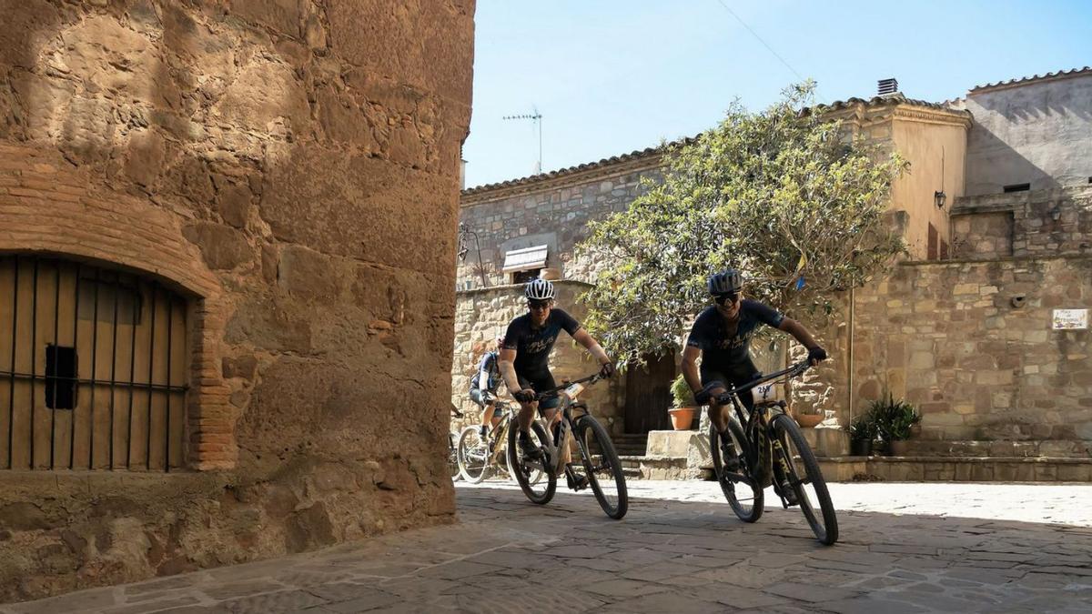 Un grup de ciclistes enfila un revolt al tram del recorregut que travessava el raval de Salelles | JOAN CLOSAS JUNYENT