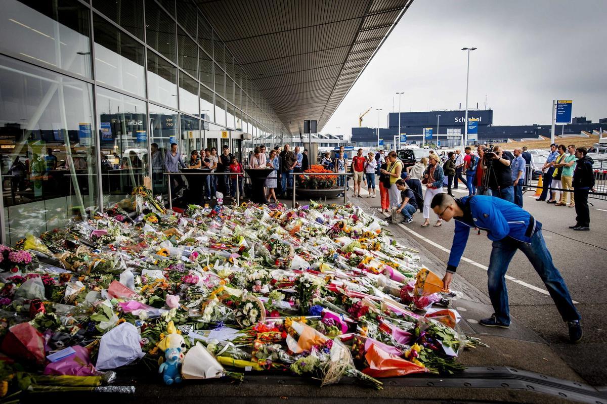 SCH01 SCHIPHOL (HOLANDA) 21/07/2014.- Un ciudadano deposita un ramo de flores en memora de las víctimas del vuelo MH17 de Malaysia Airlines en el aeropuerto Schiphol, cerca de Ámsterdam (Holanda) hoy, lunes 21 de julio de 2014. El ministro de Asuntos Exteriores holandés, Frans Timmermans, busca hoy en Naciones Unidas el apoyo de la comunidad internacional para conseguir repatriar cuanto antes a las 193 víctimas holandesas de la catástrofe aérea en Ucrania oriental. EFE/Robin Van Lonkhuijsen