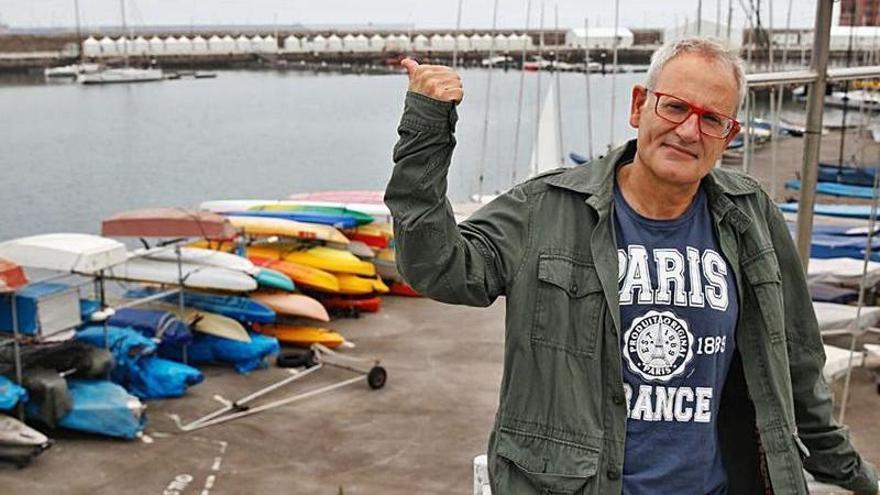 Ángel de la Calle, con los puestos de la “Semana negra”, al fondo, en el muelle de Gijón. | ÁNGEL GONZÁLEZ