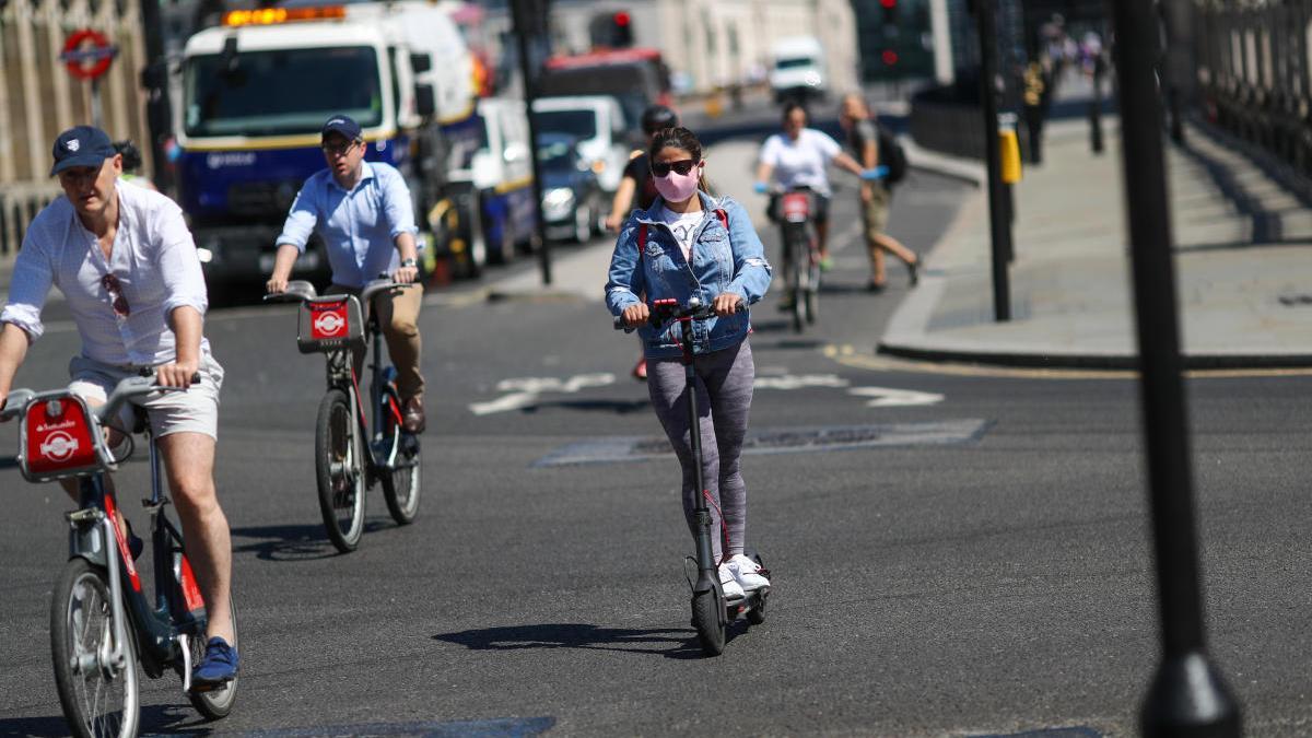 Gent amb patinet i bicicleta pel centre de Londres durant la pandèmia