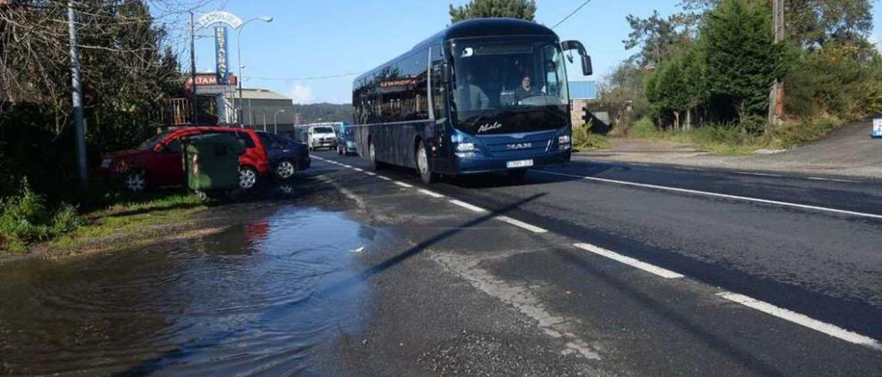 La parada de autobús en la N-640, donde se forma un charco de grandes dimensiones. // Noé Parga