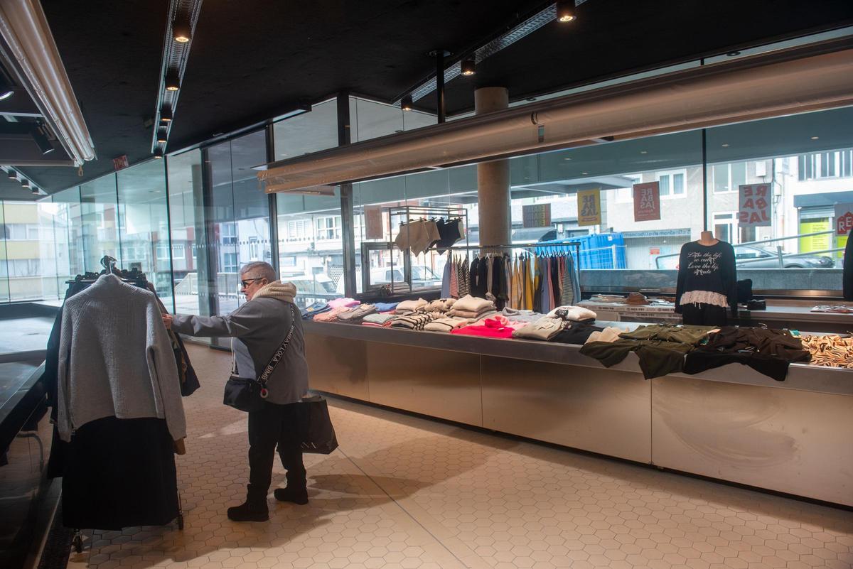 Una clienta mira las prendas de la tienda de Maica Alvedro en el Mercado de Monte Alto.