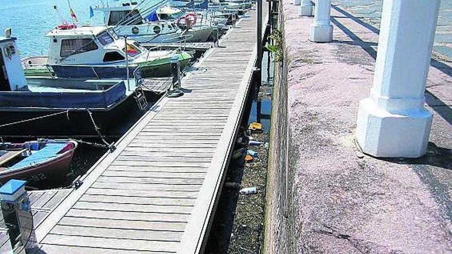 Basura acumulada en uno de los pantalanes de la zona deportiva de San Esteban. A la derecha, interior de uno de los edificios del puerto.