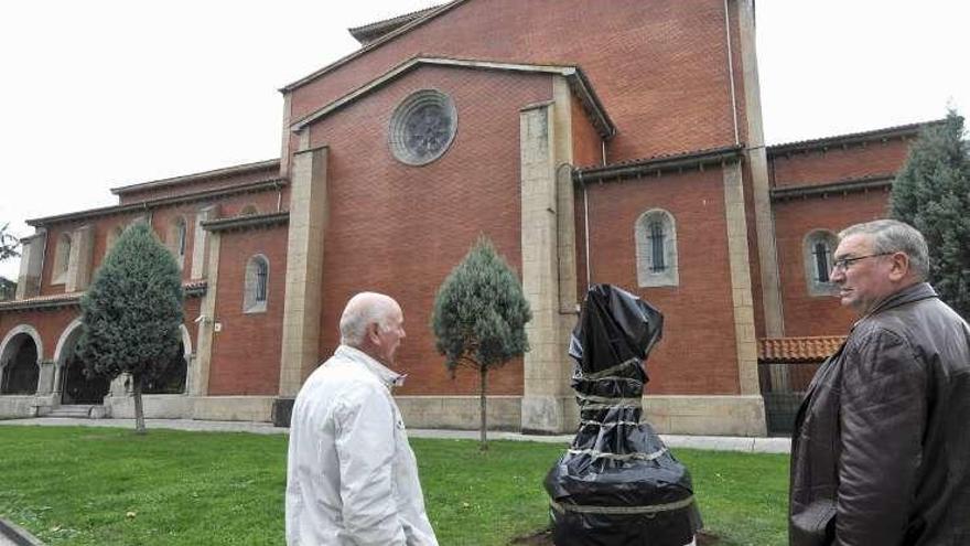 Dos vecinos, ante la estatua tapada de Rufino Roces.