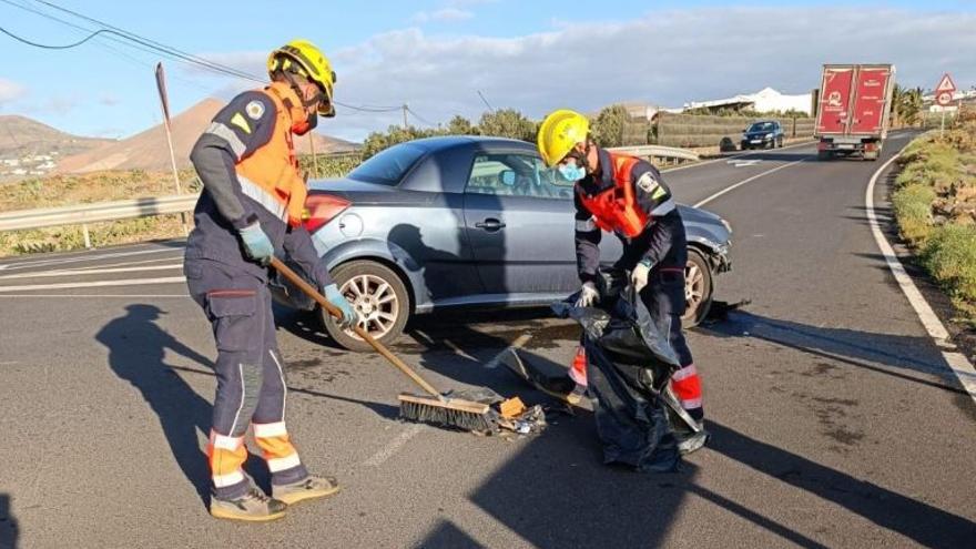 Bomberos limpiando la calzada en el accidente