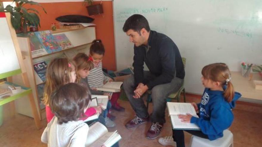 Un padre comenta un cuento con cinco niñas de Infantil de 5 años en el colegio La Aneja de Alicante y, a la derecha, un aula de un centro que introduce la luz como elemento.