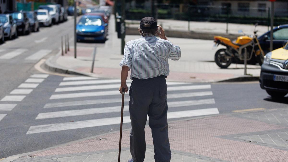 Un hombre mayor pasea apoyándose en un bastón.