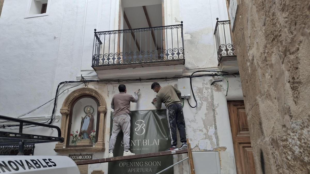 Dos operarios pican la fachada del futuro hotel