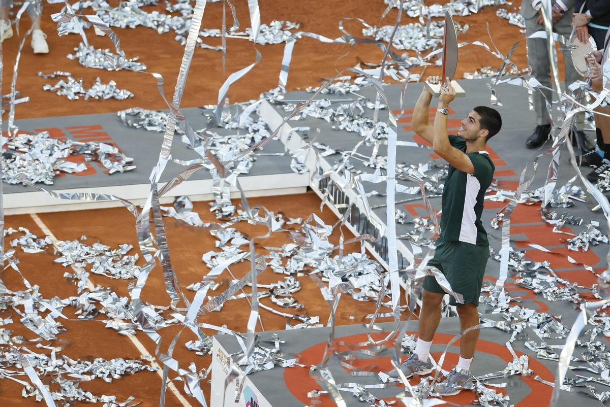 MADRID, 08/05/2022.- El tenista español Carlos Alcaraz alza el trofeo mientras celebra su victoria en la final de la Mutua Madrid Open tras derrotar al alemán Alexander Zverev en el encuentro disputado este domingo en las instalaciones de la Caja Mágica, en Madrid. EFE/Juanjo Martín.