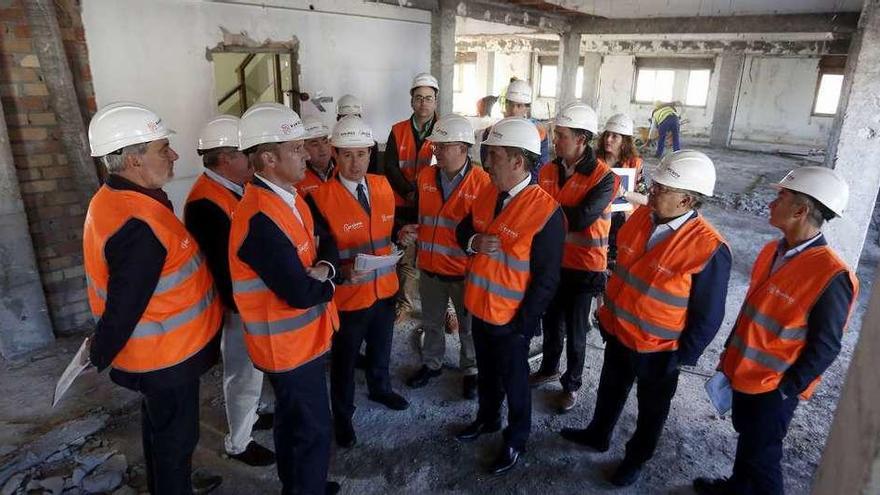 Los conselleiros Alfonso Rueda y Valeriano Martínez, con técnicos y otros cargos, en el interior del edificio en plena rehabilitación. // FdV