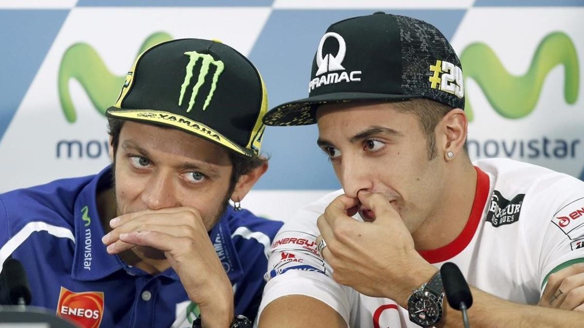 Andrea Iannone, a la derecha, dialoga con Valentino Rossi.