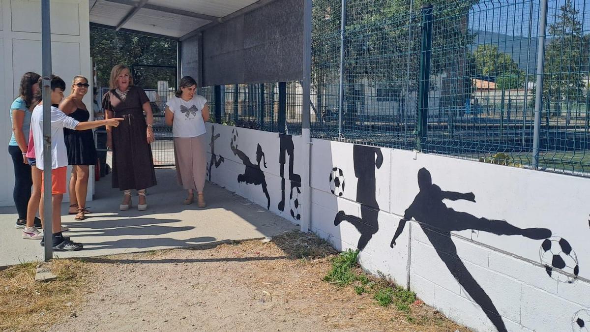 La alcaldesa Digna Rivas y la concejala de Xuventude, Iria Vilaboa, visitan uno de los murales realizados el pasado año.