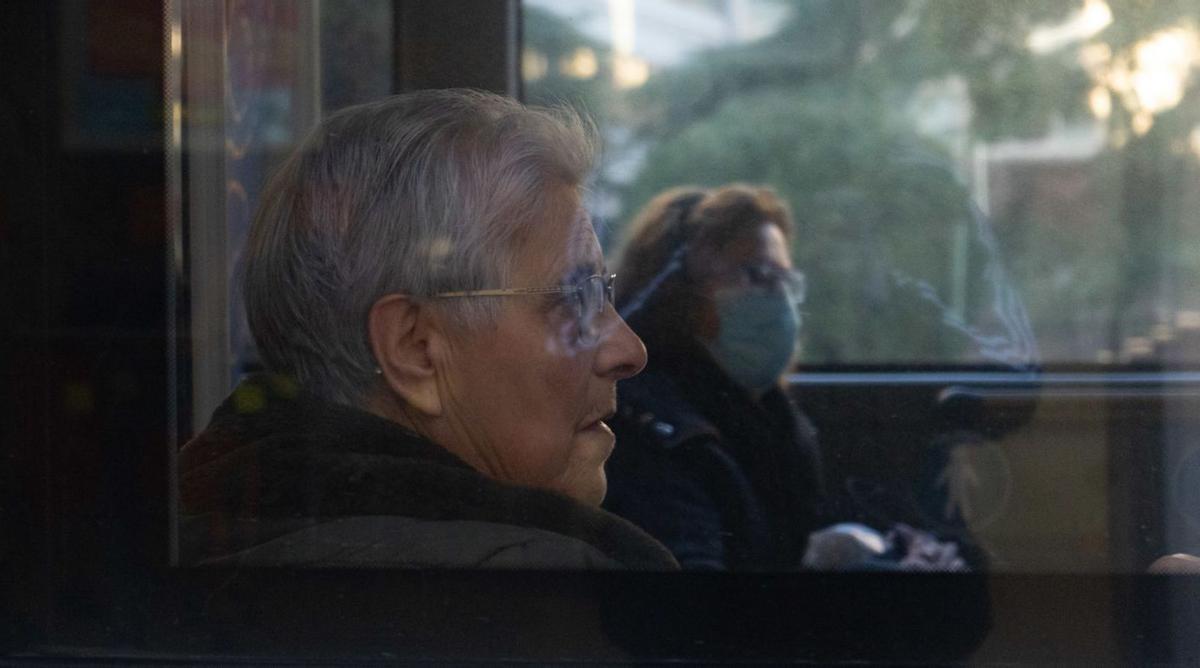 Dos mujeres, una con mascarilla y otra sin ella, en el interior de un autobús urbano. | Jose Luis Fernández