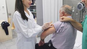 Un hombre mayor es inoculado con la vacuna de la gripe.