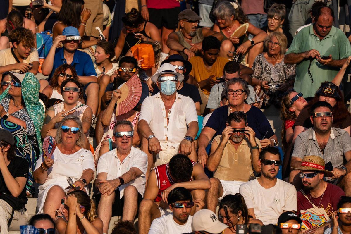 Ciudadanos en el Port Marina Tarraco, reunidos para contemplar el eclipse total de Sol.