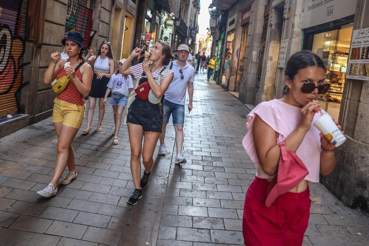 45º, récord de calor histórico. En la imagen, unas turistas se alivian del calor en la calle de la Llibreteria, en Barcelona, el 18 de julio del 2023