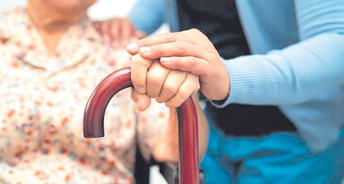 Una persona se apoya en su bastón.