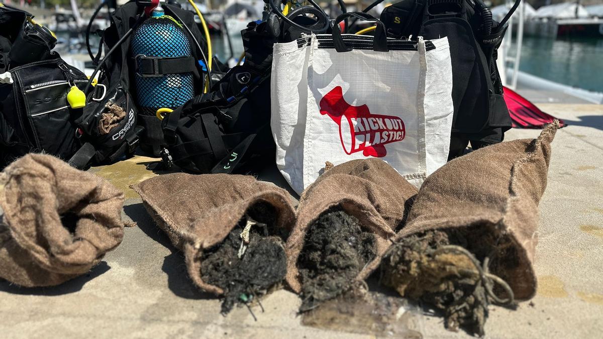 Cuatro de los sacos llenos de residuos recién salidos de las plataformas hundidas que hay delante de la playa de la Mar Bella.