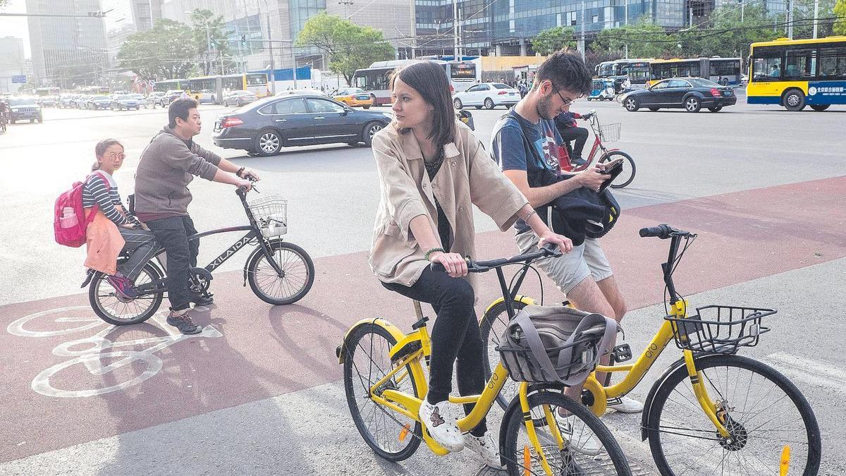 Turistas occidentales en bicicleta por la capital de China, Pekín.