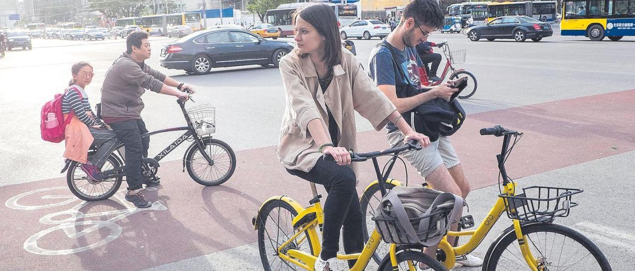 Turistas occidentales en bicicleta por la capital de China, Pekín.