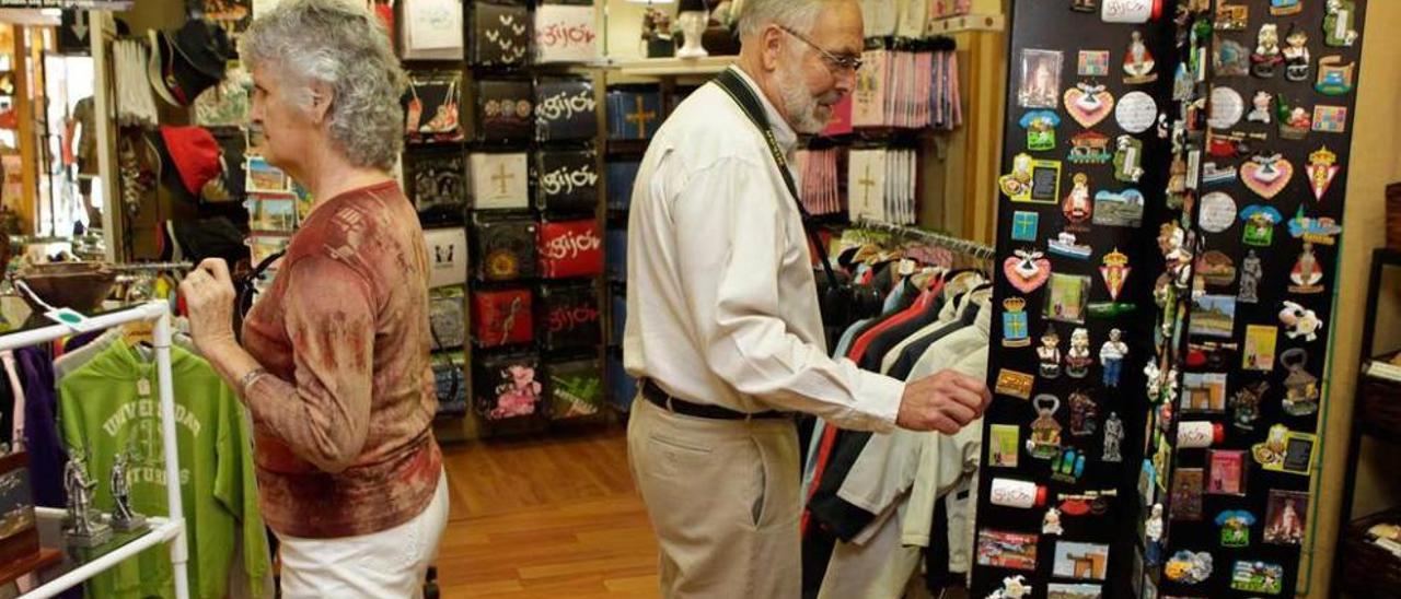 Turistas llegados en un crucero a Gijón, de compras en una tienda.