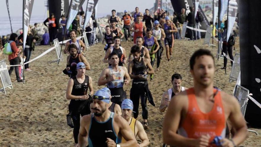 Triatletas saliendo del agua en una carrera en Poniente.