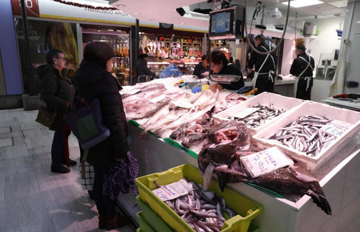 Dos mujeres compran pescado en la plaza de abastos de Avilés. | RICARDO SOLÍS