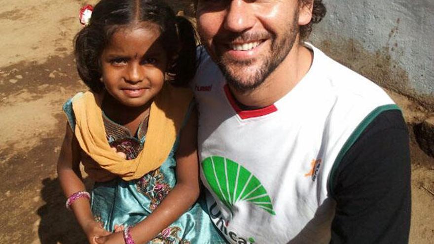 Christian Jongeneel posa con una niña durante su último desafío en la India para la ONG Brazadas Solidarias.