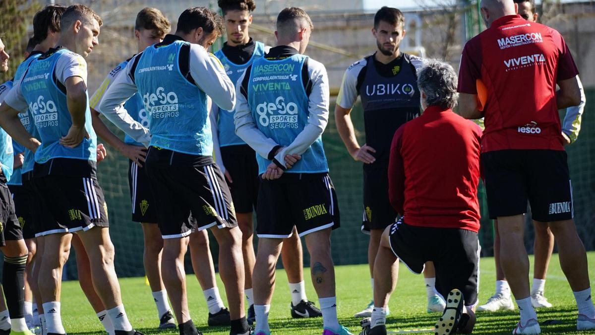 Pablo Alfaro de rodillas da instrucciones a sus jugadores en un entrenamiento