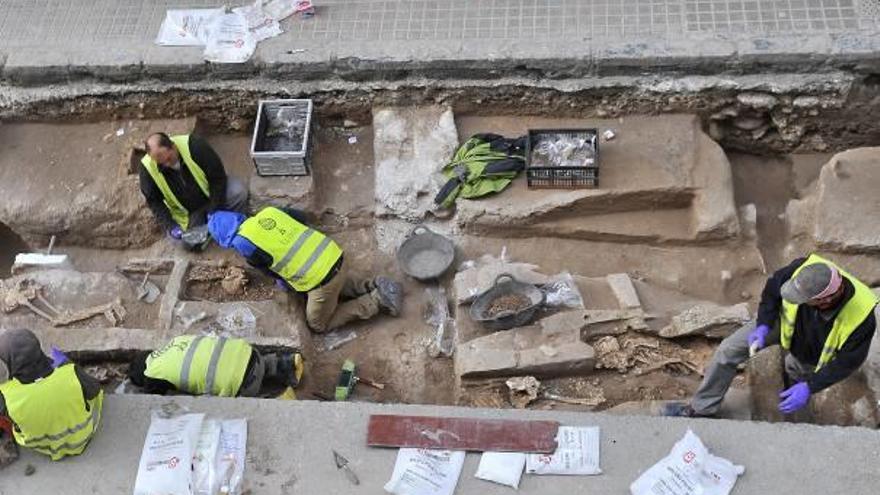 Los arqueólogos retiran ayer por la tarde los esqueletos hallados junto al Mercado Central.