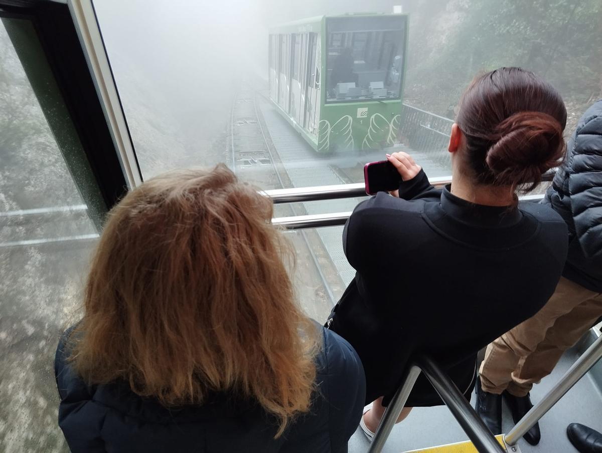 Viatgers a l'interior del funicular de Sant Joan de Montserrat durant un trajecte