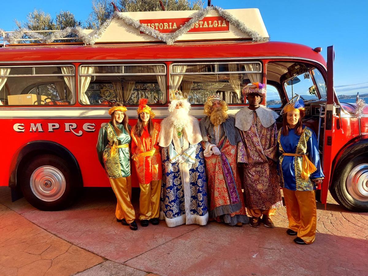 Los Reyes posan en Ribeira ante el autobús de época de la emprea Cuiña.