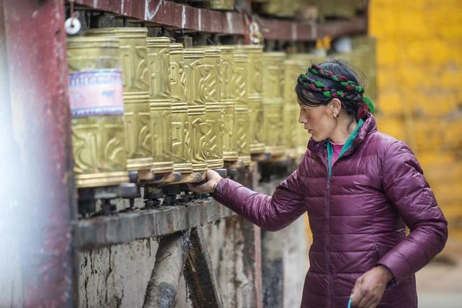 Una peregrina gira ruedas cilíndricas de oración en Lhasa