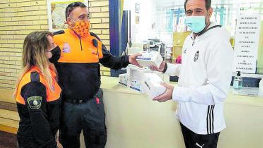 Voluntarios de Protección Civil entregan las mascarillas. | DANIEL TORTAJADA