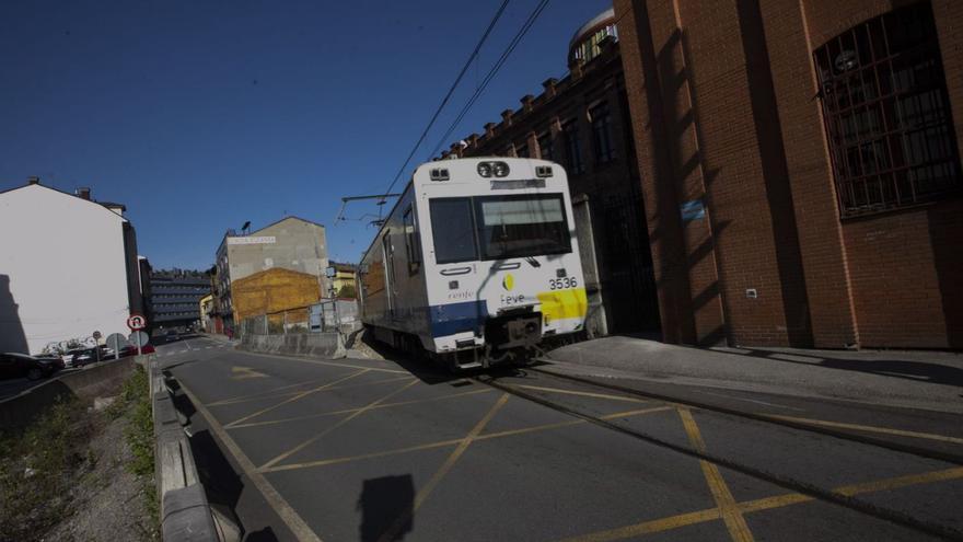 Un tren enfila la recta de Valnalón, en La Felguera. | Miki López