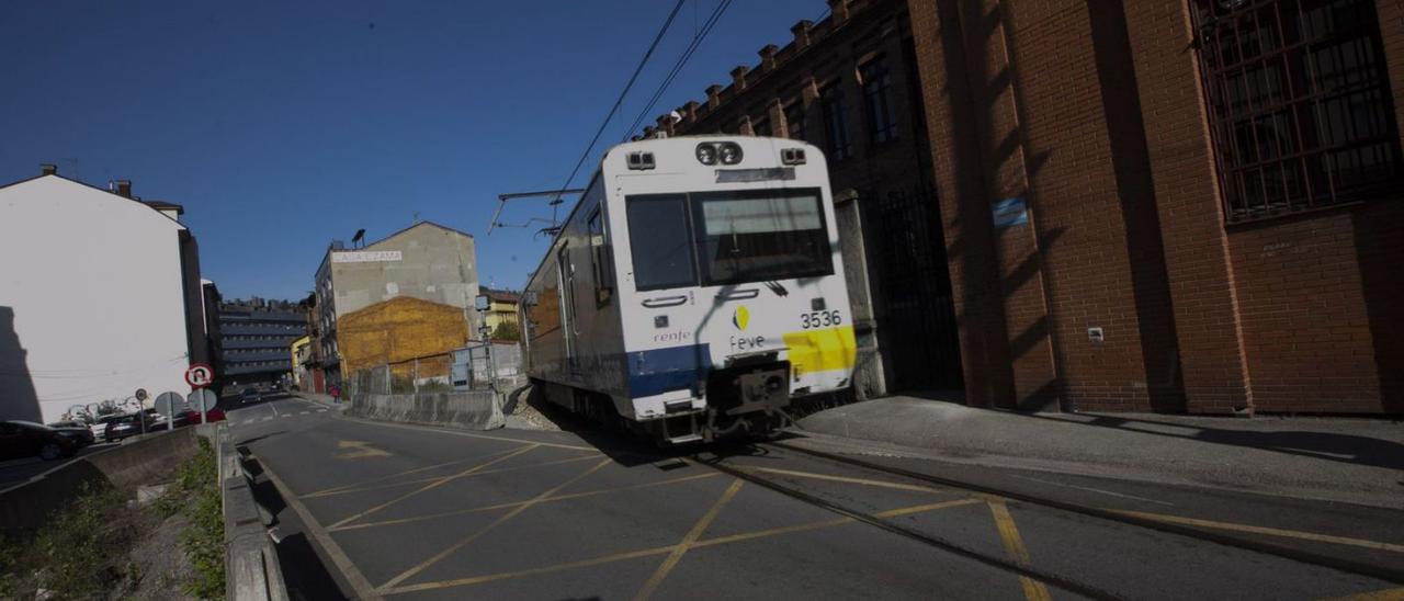 Un tren enfila la recta de Valnalón, en La Felguera. | Miki López