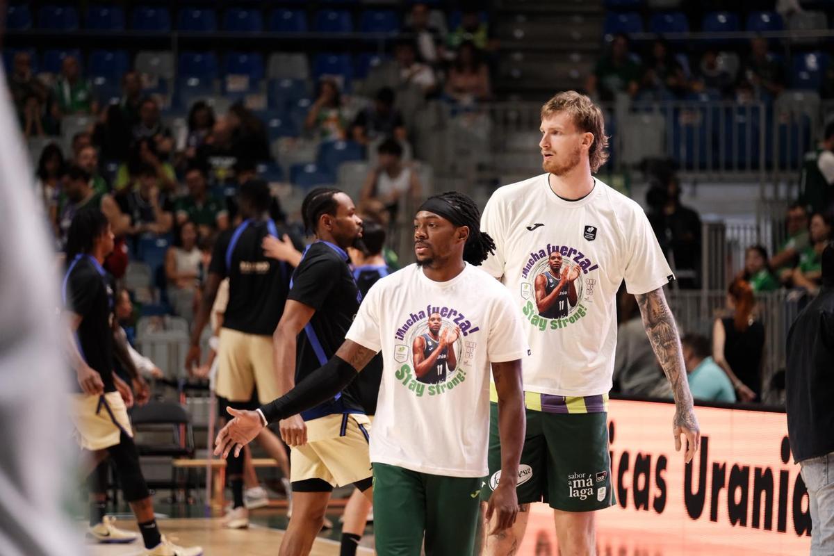 Los jugadores del Unicaja mandan ánimos a Carter con una camiseta en el calentamiento frente al Barça