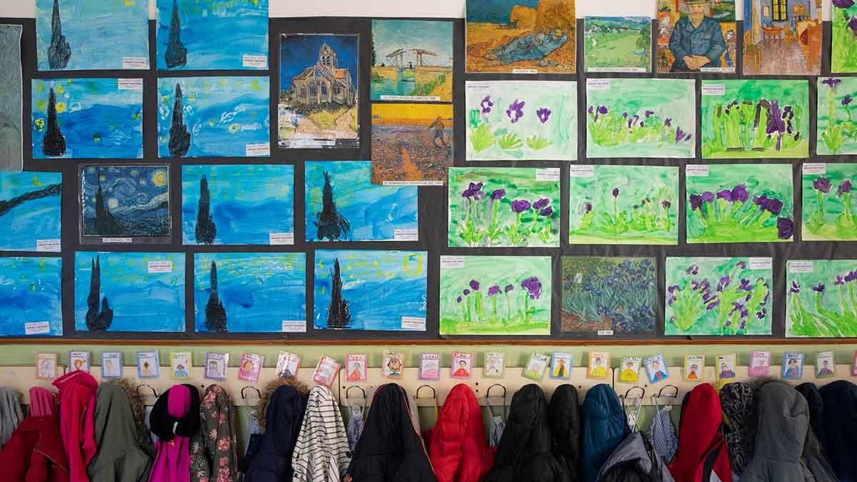 Classe de primària decorada amb els dibuixos artístics dels alumnes.