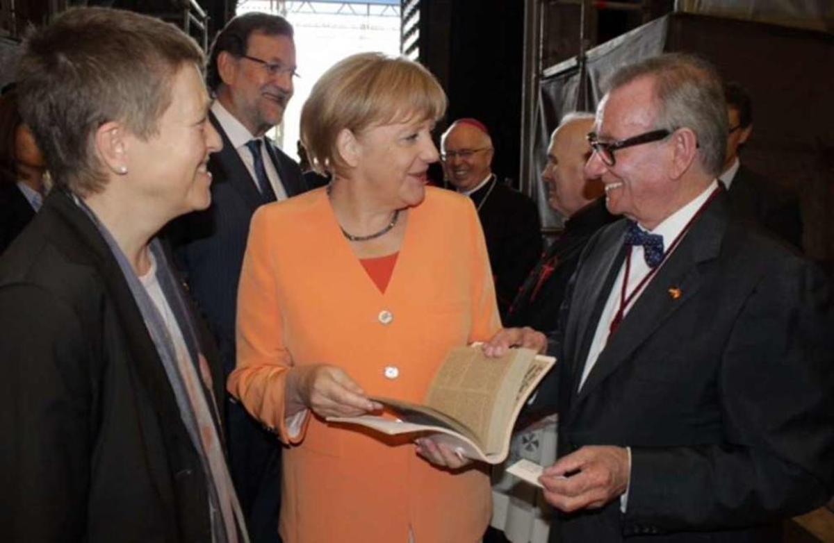 Cándido Pazos, en el momento de entregar su Códice Calixtino a la canciller Angela Merkel.