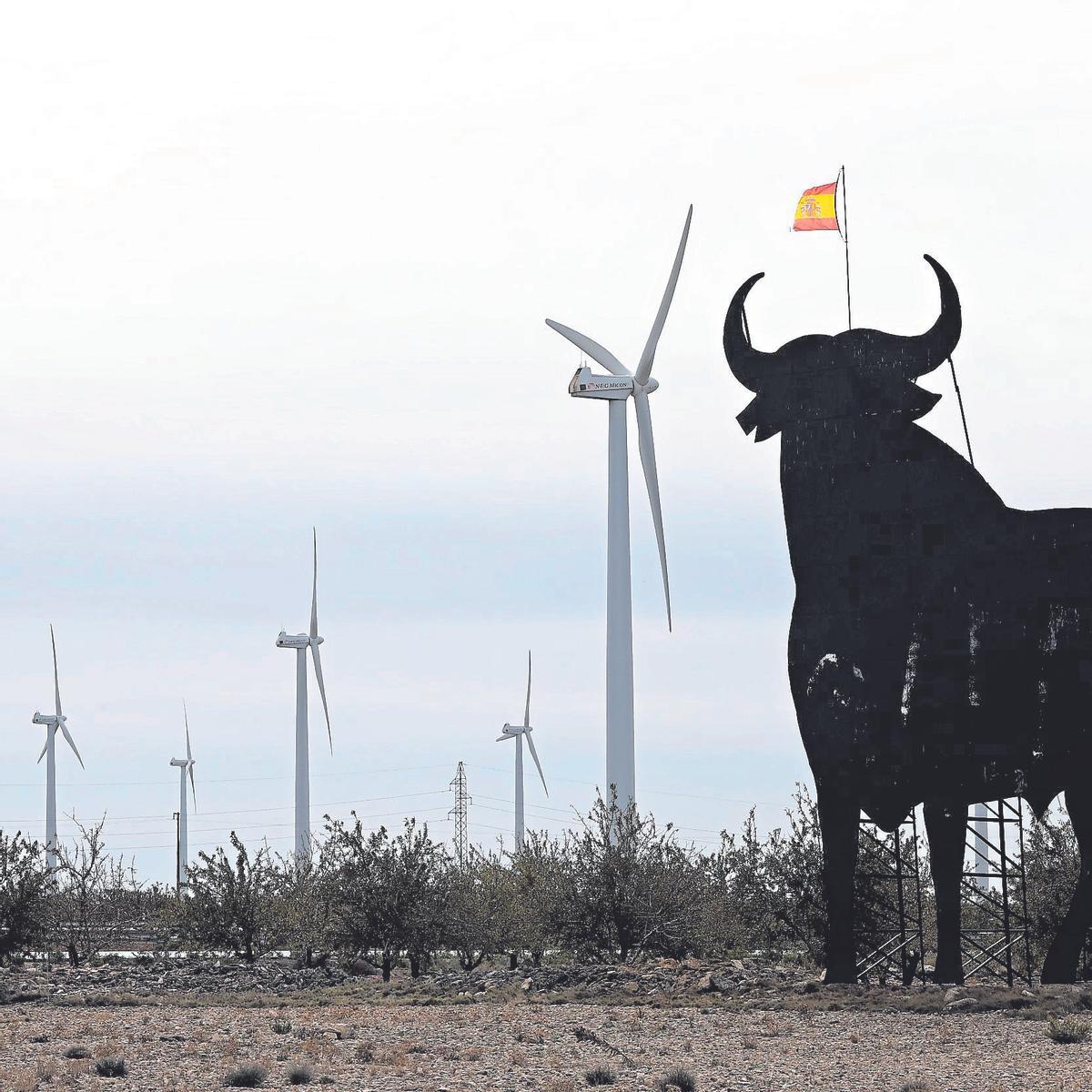 Varios molinos de viento en La Muela junto a la silueta del emblemático toro de Osborne.
