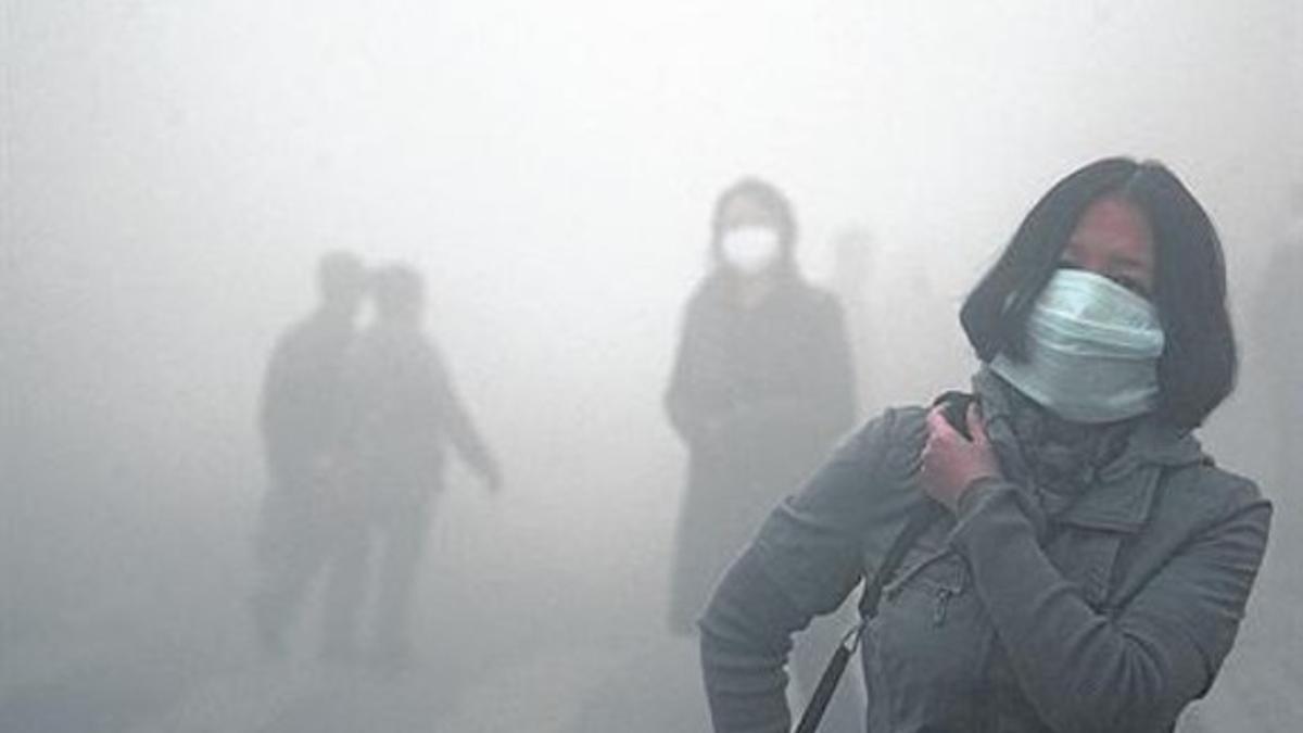 Caminantes con máscaras contra la contaminación en Harbin, China.