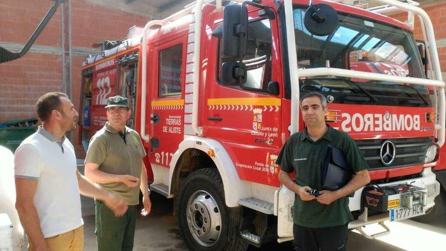 Varias personas junto a uno de los dos camiones autobomba del parque de bomberos de San Vitero.